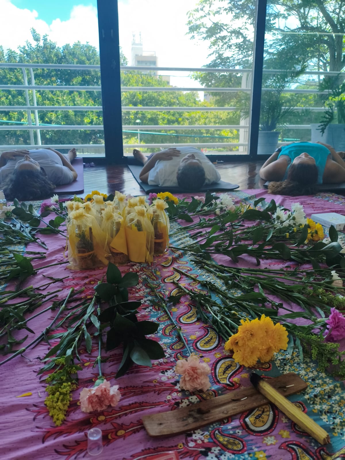 Círculo de mujeres en un encuentro de sanación, con altar de flores e incienso